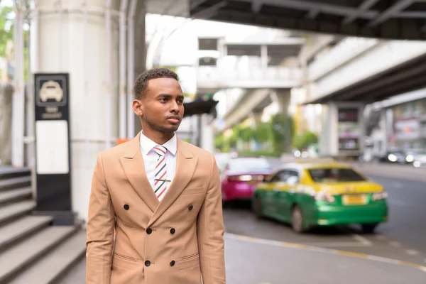Νεαρός όμορφος Αφρικανός επιχειρηματίας περιμένει ταξί στην πόλη — Φωτογραφία Αρχείου