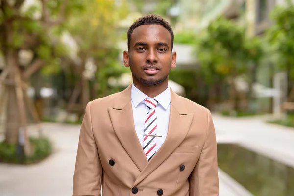 Joven hombre de negocios africano guapo con naturaleza en la ciudad —  Fotos de Stock