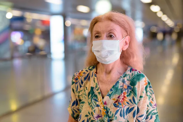 Szőke idős nő portréja maszkos társadalmi távolságban a metróállomáson — Stock Fotó