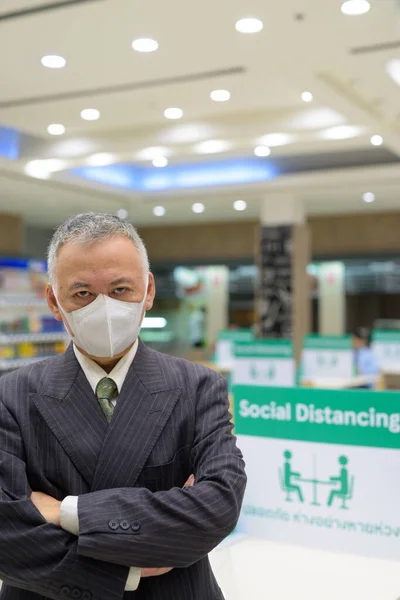 Homme d'affaires japonais mature avec masque de distance sociale à la cour de nourriture — Photo