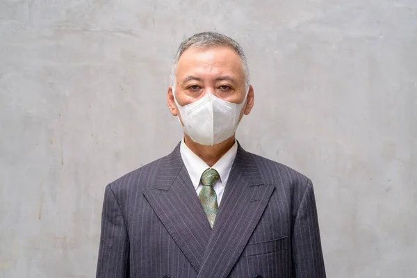 Visage d'homme d'affaires japonais mature avec masque à l'extérieur — Photo