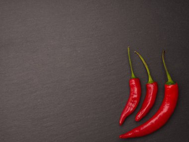 Karanlık arduvaz arka plan üzerinde kırmızı biberli