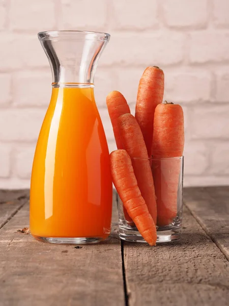 Suco com cenouras orgânicas em uma mesa — Fotografia de Stock