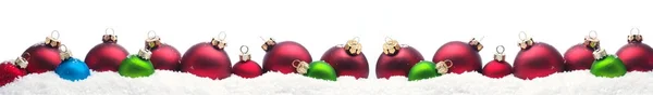 Красочные рождественские безделушки в снегу — стоковое фото