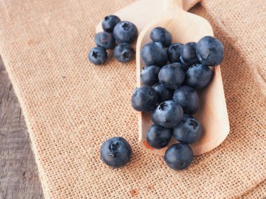 Bir tahta kaşık üzerinde taze yaban mersini