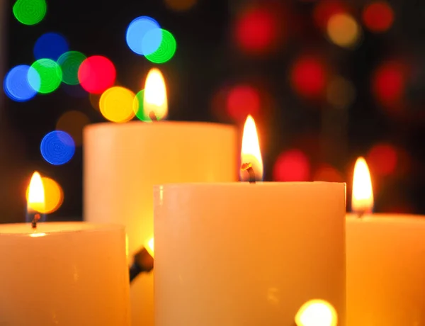 Cztery płonące świece adwentowe z lampkami świątecznymi — Zdjęcie stockowe