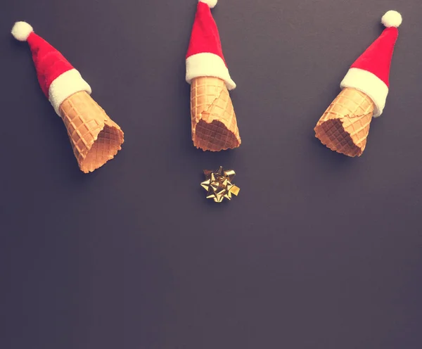 Ice cream cones with hat of Santa and a golden bow — Stock Photo, Image