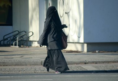 Woman in the burqa walking clipart