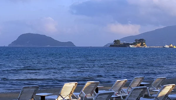 Шезлонги на пляже Лаганас с островом Марафониси и островом Камео — стоковое фото