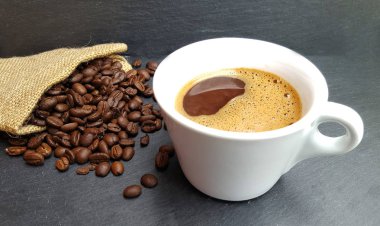 Kahve fincanı ve koyu arka plan üzerinde fasulye