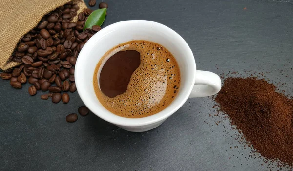 Coffee cup, beans and ground powder on dark  background — Stock Photo, Image