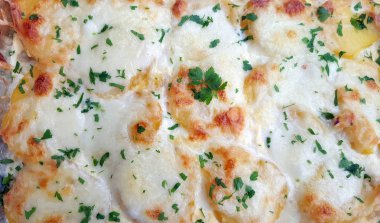 Bir güveç çanağı tamamen kızarmış patates peynir ile