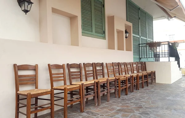 Fila de sillas de madera en frente de la casa en Grecia —  Fotos de Stock