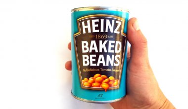 THESSALONIKI, GREECE - December 3, 2017: Hand holding a tin of Heinz Baked Beans in tomato sauce clipart