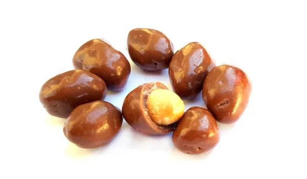 Amendoins em chocolate em um fundo branco — Fotografia de Stock