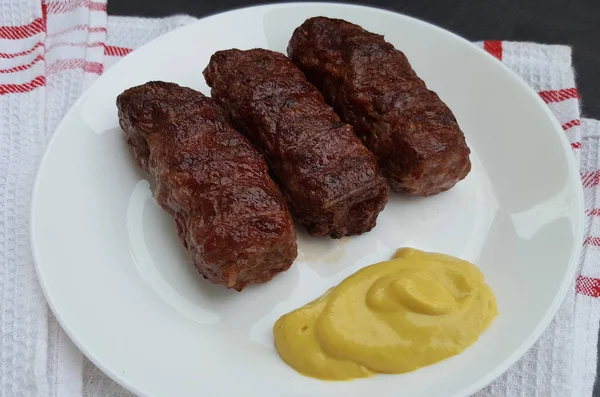 Rouleaux de viande (mititei ou mici) nourriture roumaine traditionnelle à la moutarde — Photo