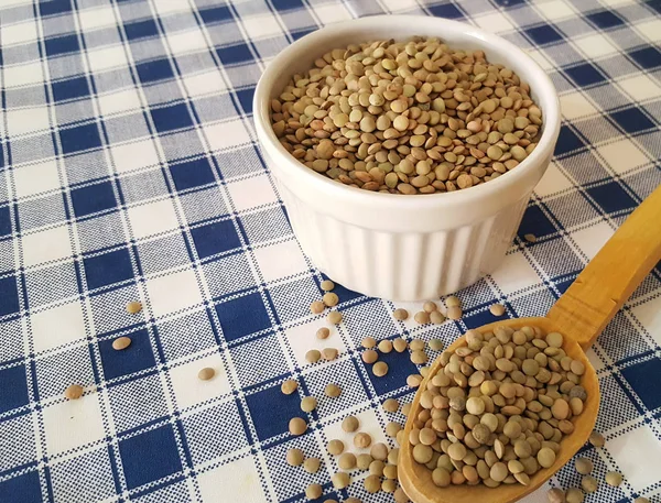 Lentilles dans un bol en céramique et cuillère sur la table — Photo