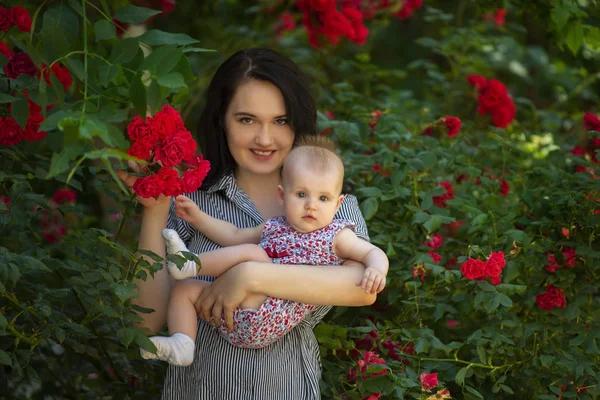 Madre y su chiid con flores de rosas — Foto de Stock