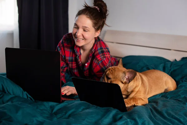 Ung Flicka Och Hennes Hund Franska Bulldog Arbetar Sängen Bärbar Stockbild