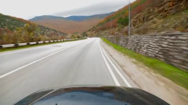 De auto rijdt over een smalle bergweg. — Stockvideo