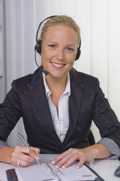 Femme amicale avec casque dans le service à la clientèle — Photo