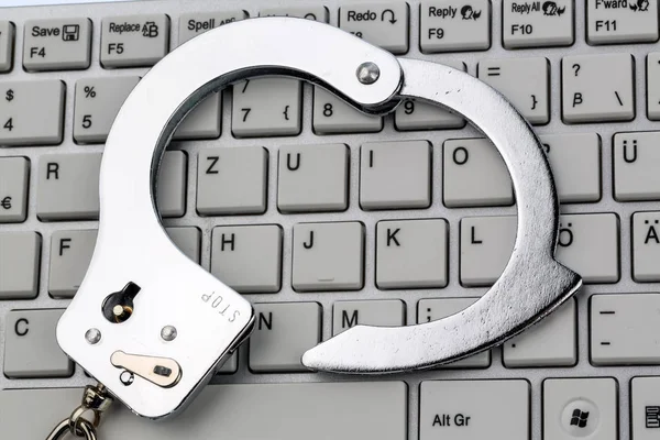 Handcuffs on computer keyboard — Stock Photo, Image