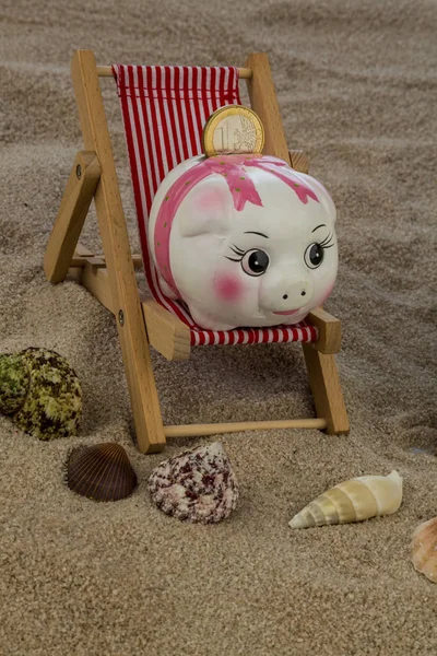 Deckchair with piggy bank and euro — Stock Photo, Image