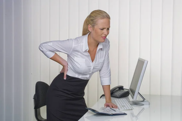 Vrouwen in het kantoor met lage rugpijn — Stockfoto