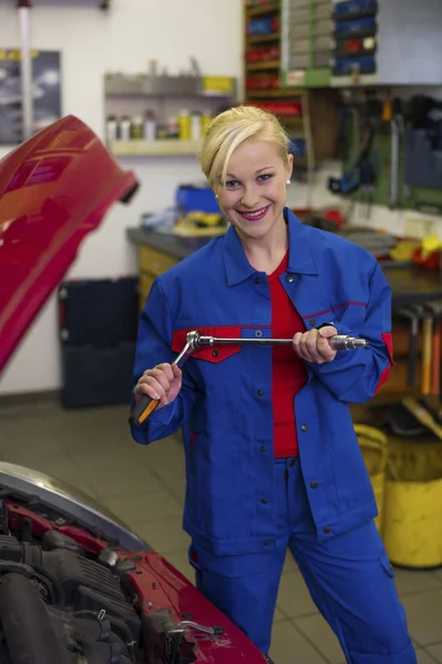 自動車修理工場で整備士として働く女性は — ストック写真
