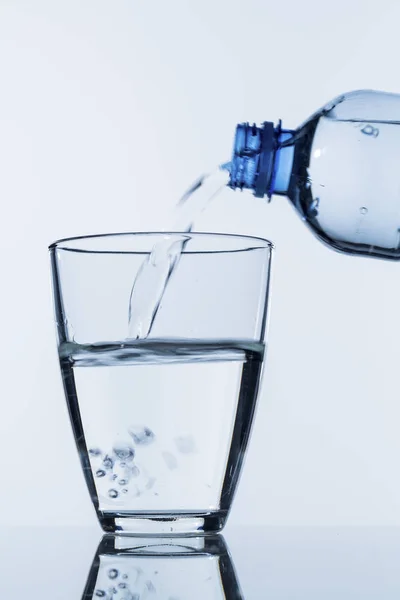 Налить воду в стакан — стоковое фото