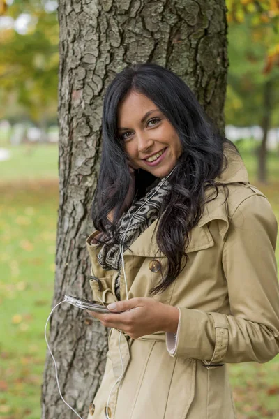 Vrouw luistert naar muziek op mobiele telefoon — Stockfoto