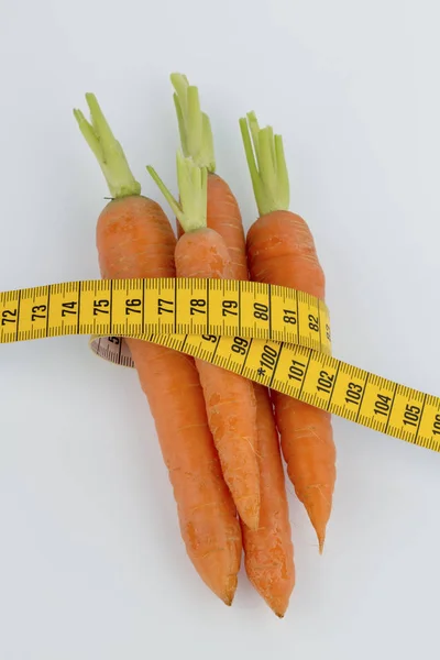 Fresh carrots with tape measure — Stock Photo, Image