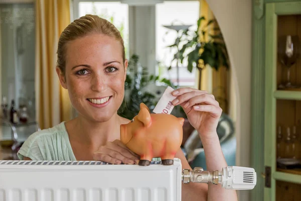 Woman with radiator and piggy bank — Stock Photo, Image