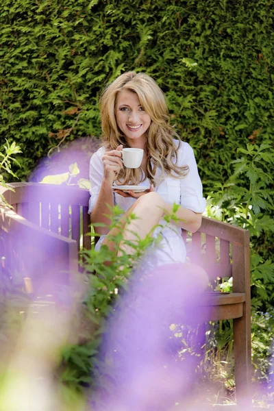 Donna che beve caffè a colazione in giardino — Foto Stock