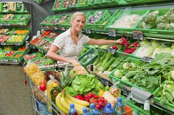 Kvinna shopping för frukt och grönsaker — Stockfoto