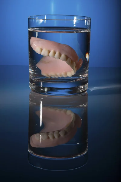 Prótesis dentales en una taza de té — Foto de Stock