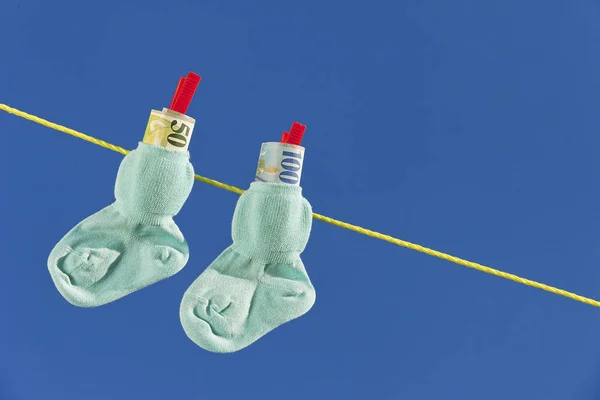 Baby socks on clothesline with swiss francs — Stock Photo, Image