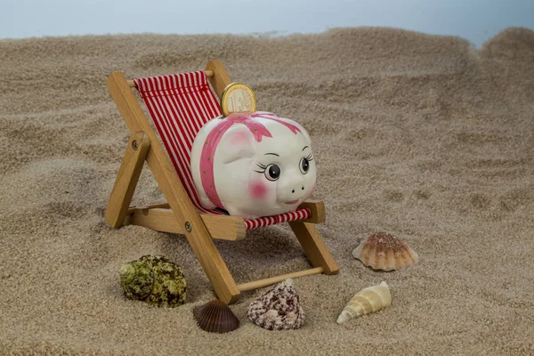 Deck chair with piggy bank and euro — Stock Photo, Image