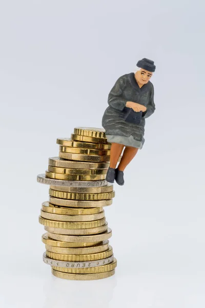 Pensioner is sitting on a pile of money — Stock Photo, Image