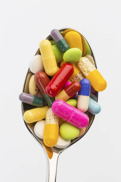Багато таблеток на ложці — стокове фото