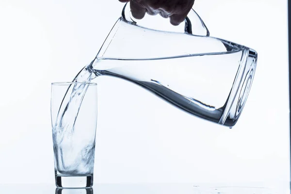 Glass with water and pitcher — Stock Photo, Image