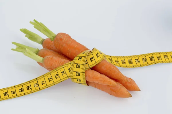 Fresh carrots with measure tape — Stock Photo, Image