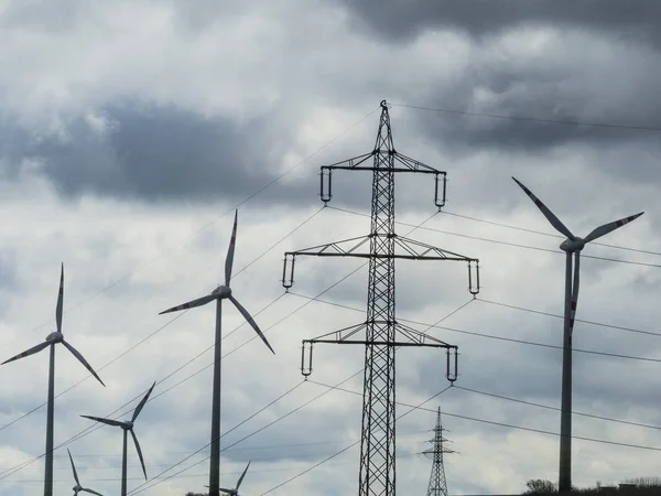 Windmill and electricity pylons — Stock Photo, Image