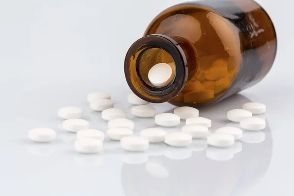 Muitos comprimidos com recipiente — Fotografia de Stock
