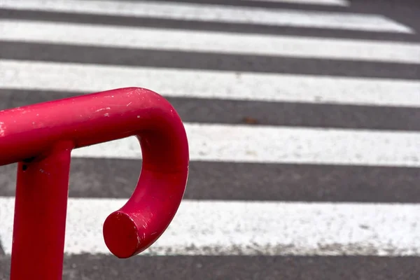 Red railing in front of crosswalk — Stock Photo, Image