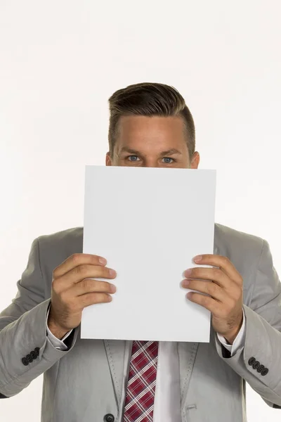 Gerente sostiene hoja en blanco en frente de la cara — Foto de Stock