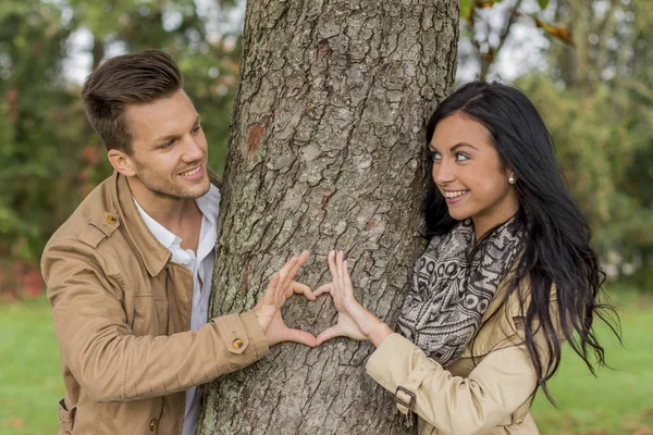 Couple in love behind a tree — Stock Photo, Image