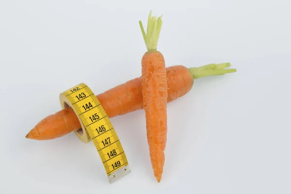 Fresh carrots with measure tape — Stock Photo, Image