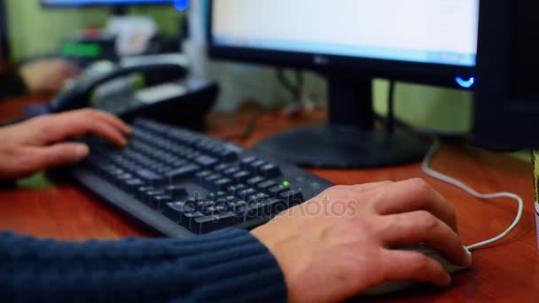 Man,sit in the armchair, talking on the phone. On a computer screen he view financial information. Closeup. Shallow depth of field — Stock Video