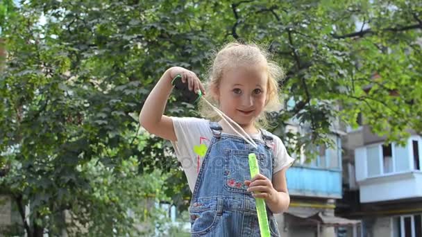 Little girl blowing soap bubbles — Stock Video